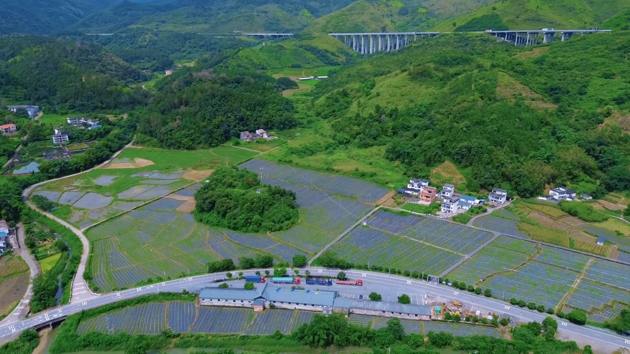 高速桥与群山环绕的黄坌镇农业基地航拍图